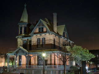 Photo of a beautifully illuminated Victorian house at night