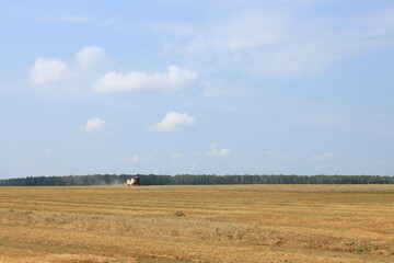 Harvester harvesting crops on a sunny summer day