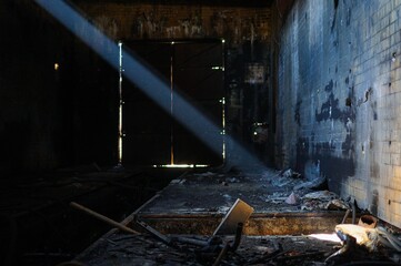 Single sunbeam illuminating the interior of an old abandoned factory.