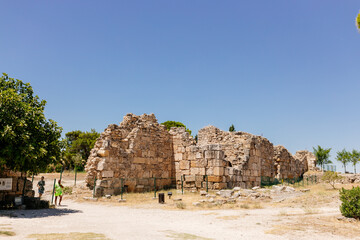 Half-ruined buildings of the ancient city, Journey to the old city. Preserved old columns against the backdrop of a mountain landscape. Hierapolis Ancient City, Pamukkale, T&uuml;rkiye - July 29, 2023