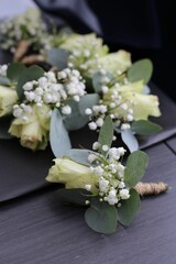 Decorative table arrangement featuring several wedding boutonnieres, accented with vibrant flowers