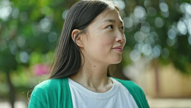 Young chinese woman smiling confident breathing at park