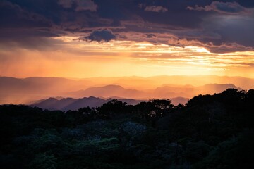 Fototapeta na wymiar Stunning sunset illuminates the landscape of a misty mountain range.