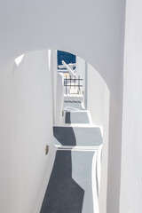 Traditional Greek architecture, white washed walls; stairways leading down to the sea.  On the island of Santorini.