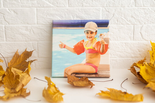 Canvas with printed photo of happy family in outdoor swimming pool on white wall in living room