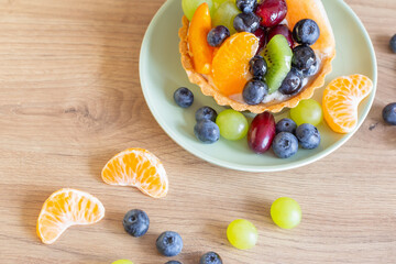 cupcakes with fruits on wooden table on kitchen