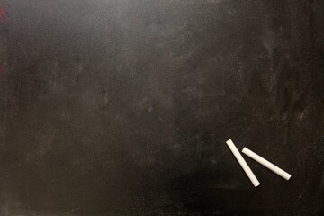 Closeup of a black chalkboard with chalks under the natural light © Rawf8/Wirestock Creators