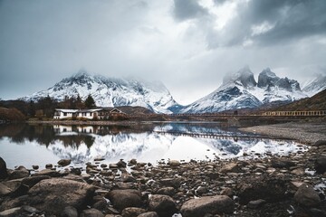 Houses, bridge and mountains reflected in the water in Torres del Paine National Park
