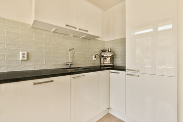 a kitchen with white cupboards and black counter tops on the counters in this is an example of modern design