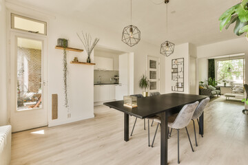 a dining room with white walls and wood flooring in the center of the room, there is a large black...