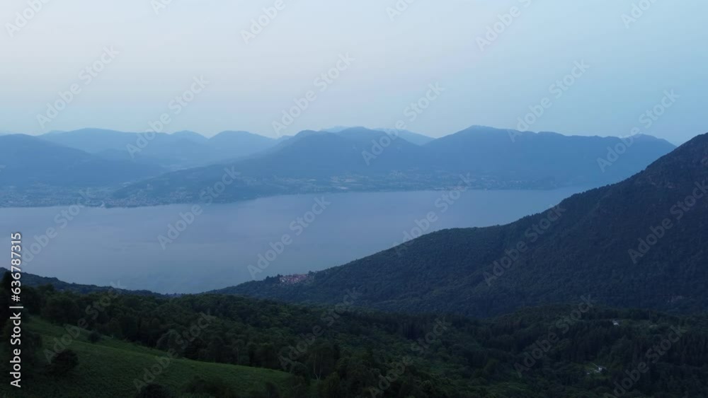 Wall mural Aerial landscape of green forested hills with a lake view at sunrise