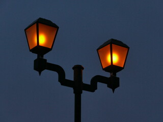 Fototapeta na wymiar 青い暗闇にオレンジ色に光るレトロな街灯