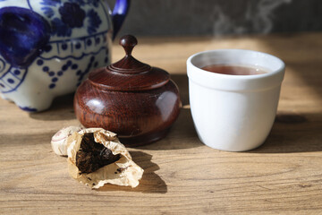 木製テーブルに置いたプーアル茶と茶葉