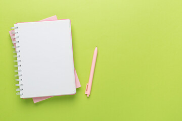 Notebook with stationery on color background, top view
