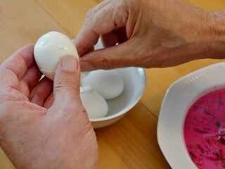 Fototapeta na wymiar Hand schält Eier für Rote-Bete-Suppe