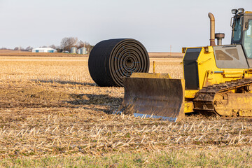 Bulldozer and field tile in farm field. Water drainage, soil conservation and agriculture flooding control concept © JJ Gouin