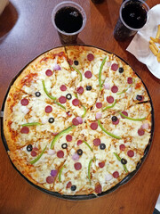 pizza with salami and cheese,Glass of soft drink and pizza on the table