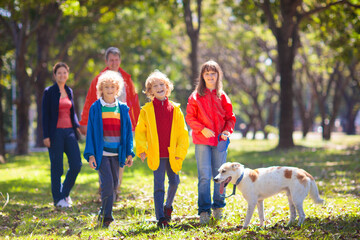 Family walking in autumn park. Fall fun.