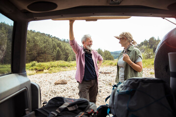 Senior couple packing and getting ready to go out hiking and camping in the forest