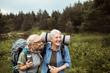 Senior lesbian couple hiking in the forest together