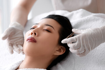 Obraz na płótnie Canvas Young Asian woman undergoing treatment in beauty salon. Skin care concept