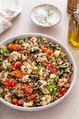 Warm quinoa salad with roasted vegetables and fresh tomatoes