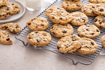 Chocolate chip cookies on a cooling rack with flaky salt served with milk