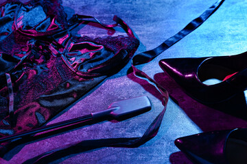 Sexy underwear with whip and heels on dark background