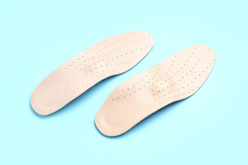 Leather orthopedic insoles on color background