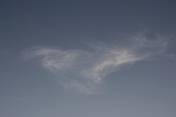Obraz premium Wispy clouds in the sky, in a swirly, triangular shape