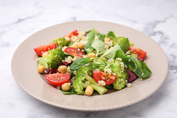 Healthy meal. Tasty salad with quinoa, chickpeas and vegetables on white marble table, closeup