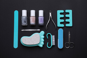 Set of pedicure tools on black background, flat lay