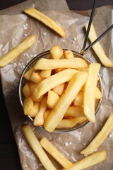 Frying basket with tasty french fries on table, flat lay