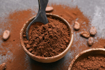 Bowls with cocoa powder on black background