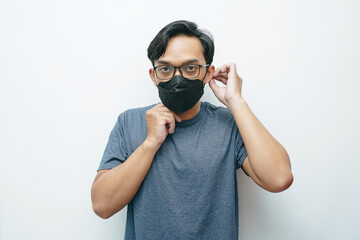 Portrait of an Asian Indonesian man wearing protective mask to prevent infection virus or bad air quality. isolated white background