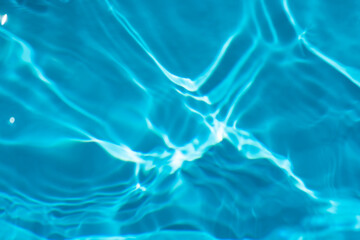 Blue water with ripples on the surface. Defocus blurred transparent blue colored clear calm water surface texture with splashes and bubbles. Water waves with shining pattern texture background.