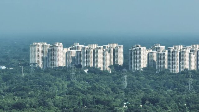 Buildings rise high above the trees, a testament to the rapid urbanization taking place in the city. The skyline is changing rapidly, with new buildings being constructed all the time.