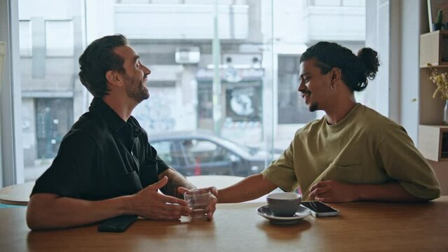 Couple gays relaxed meeting in restaurant close up. Two guys talking smiling