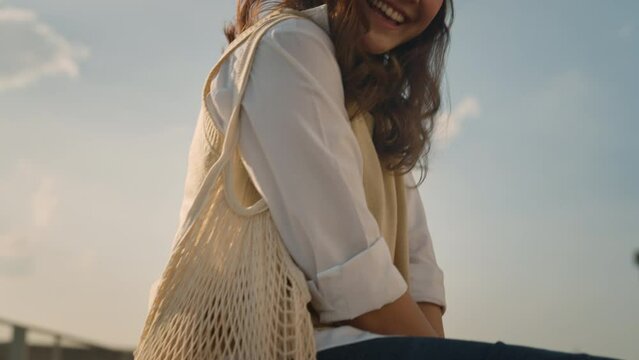 Go Green Save the planet earth eco care net zero waste no plastic free carry mesh bag food orange fruit happy looking at camera at outdoor. Young teen asia people Gen Z girl reduce CO2 trash garbage.