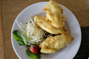 Delicious golden brown grilled banana and cheese dessert served on a white platter