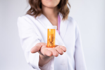 The pharmacist or doctor holding medication or medicine for treatment. Anti biotic pill in the vial. - Powered by Adobe