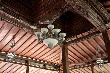 ancient chandeliers on ancient Javanese carved wooden ceilings
