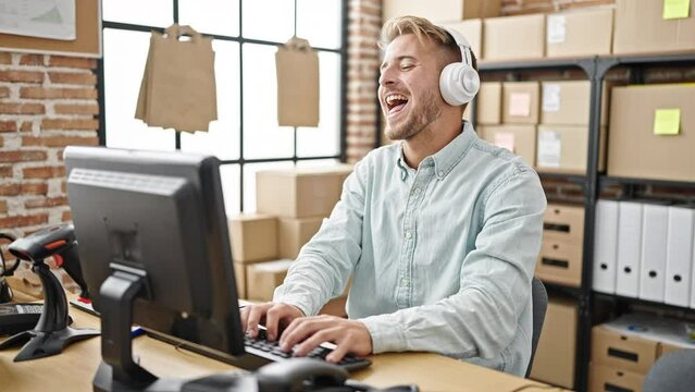 Young caucasian man ecommerce business worker listening to music dancing at office