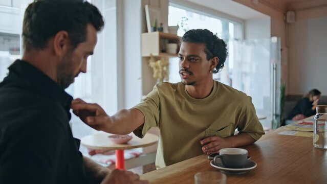 Multiethnic men flirting cafe close up. Two relaxed guys talking in cafeteria