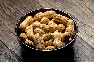 Peanuts with nutshell on a bowl, studio shot