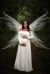 A woman expecting a child depicted as a forest fairy.