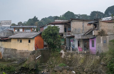 Fototapeta na wymiar densely populated residential area in the city of Bogor, densely populated area along the river, ciliwung river, landslide-prone houses in Bogor, river in the village, houses in the village