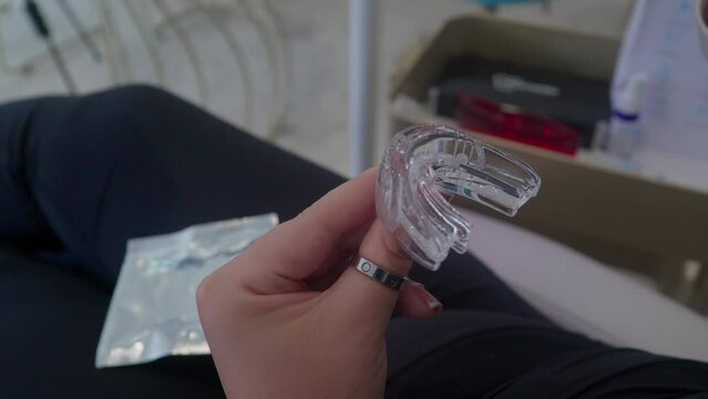 Girl putting preparing for teeth whitening in clinical environment 