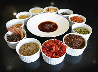 chef signature homemade spices chilli cinnamon pepper curry green leaf dry herb ingredient in bowl...