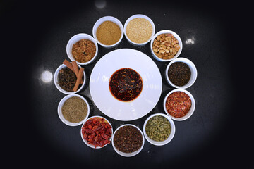 chef signature homemade spices chilli cinnamon pepper curry green leaf dry herb ingredient in bowl for laksa on black marble table asian halal food cuisine menu for restaurant